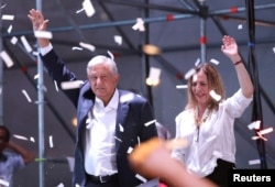 Presidential candidate Andres Manuel Lopez Obrador gestures with his wife Beatriz Gutierrez Muller as he addresses supporters in Mexico City, Mexico, July 1, 2018.