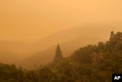 Smoke from a wildfire spreads over woods, as seen from White Rock in Carmel Valley, southeast of Monterey, Calif., Wednesday, July 27, 2016.