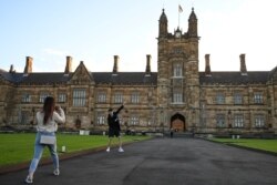 Maggie Zhang dan Sunny Gu, mahasiswa internasional asal China yang sama-sama menempuh studi Magister Commerce di University of Sydney, berfoto bersama di kampus universitas, selama wabah COVID-19, di Sydney, Australia, 11 Agustus 2020. (Foto: : REUTERS