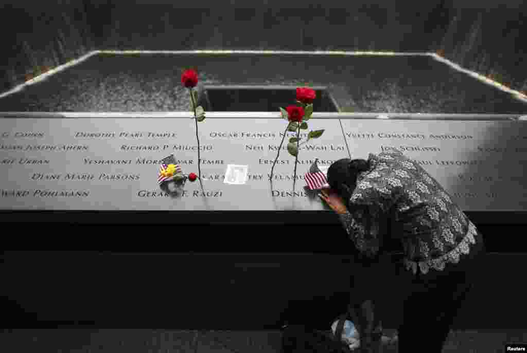 A woman grieves at the site of her husband&#39;s inscribed name at the edge of the North Pool during memorial observances on the 13th anniversary of the 9/11 attacks at the site of the World Trade Center in New York, Sept. 11, 2014.