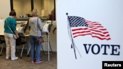 FILE - Voters cast ballots as absentee voting begins ahead of the U.S. presidential election in Medina, Ohio, Oct. 12, 2016. 