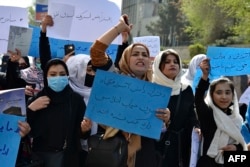 FILE - Afghan women and girls shout slogans demanding the reopening of high schools for girls during a demonstration in front of the Ministry of Education in Kabul, March 26, 2022.