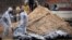 Men wearing protective gear exhume bodies of some of the civilians killed during the Russian occupation of Bucha, on the outskirts of Kyiv, Ukraine, April 13, 2022.