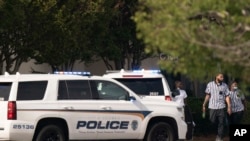 Mall employees walk near police vehicles outside Columbiana Centre mall in Columbia, S.C., following a shooting, April 16, 2022.