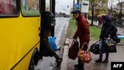 People board a bus leaving Severodonetsk, in eastern Ukraine's Donbass region, on April 13, 2022 as Russian troops intensified a campaign to take the strategic port city of Mariupol, part of an anticipated massive onslaught across eastern Ukraine.