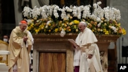 Pope Francis, right, walks past Cardinal Giovanni Battista Re during part of the Easter vigil ceremony in St. Peter's Basilica at the Vatican, April 16, 2022. 