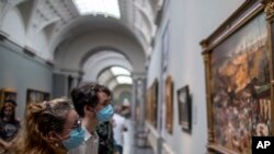 Pengunjung menikmati lukisan yang dipamerkan di Museo del Prado Madrid, Spanyol, Sabtu, 6 Juni 2020. (AP/Manu Fernandez)