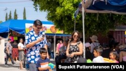 People splash water on each other but bathe the Buddha Praying for blessings for good fortune in life during Songkran and Thai New Year Celebration event at Wat Thai (Temple) Los Angeles in North Hollywood, CA