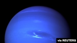 The "Great Dark Spot", a storm in the atmosphere and the bright, light-blue smudge of clouds that accompanies the storm is seen on the planet Neptune, taken by the NASA spacecraft Voyager 2 less than five days before its closest approach of the planet on 