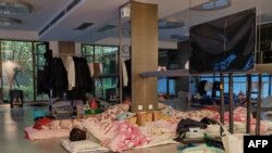 A community worker takes a nap at a temporary bed at a gym in a compound during a COVID-19 lockdown in Pudong district in Shanghai, April 13, 2022. 