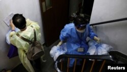 Volunteers hold anti-epidemic bags as they deliver them to residents during the COVID-19 pandemic, in Hong Kong, April 3, 2022.