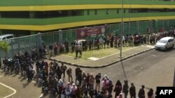 Antrean warga untuk suntik vaksin booster COVID-19 Astrazaneca di Bekasi, Jawa Barat, 29 Maret 2022. (REZAS / AFP)
