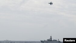 FILE - An Indonesian Airforce F-16 Jet Fighter flies over Indonesian navy warship during an operation in Natuna, near the South China Sea, Indonesia, Jan. 10, 2020 in this photo taken by Antara Foto.