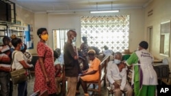 FILE - Ugandans receive Pfizer coronavirus vaccinations at the Kiswa Health Centre III in the Bugolobi neighborhood of Kampala, Uganda, Feb. 8, 2022.