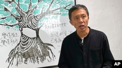 FILE - Allan Au, a veteran journalist and teaching consultant who has worked for a number of Hong Kong media outlets, speaks during a TV program in Hong Kong, Dec. 14, 2021. 