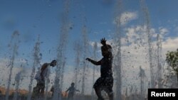 Anak-anak bermain di Domino Park di tengah gelombang panas yang melanda kawasan Brooklyn, New York, AS, 21 Juli 2019.