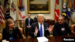 Presiden Amerika Serikat Donald Trump, didampingi CEO General Motors Mary Barra (kiri) dan CEO Fiat Chrysler Sergio Marchionne (kanan), dalam pertemuan dengan CEO industri otomotif AS di Gedung Putih, Washington, 24 Januari 2017. (REUTERS / Kevin Lamarque).