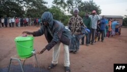 Warga Malawi antre untuk mencuci tangan dengan desinfektan di tengah pandemi Covid-19, sebelum memberikan suara di sebuah TPS di Lilongwe (foto: ilustrasi). 