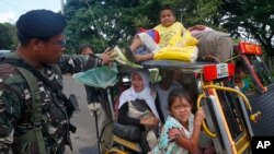 Warga yang melarikan diri dari kota Marawi yang terkepung ditanyai oleh tentara pemerintah di sebuah pos pemeriksaan, 26 Mei 2017.