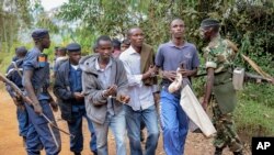 Photo d’archives : Trois hommes menottés sont emmenés par la police après avoir été arrêtés comme les organisateurs d'une manifestation de l'opposition, à Jenda, au Burundi, le 12 juin 2015. 