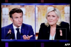 에마뉘엘 마크롱(화면 왼쪽) 프랑스 대통령과 마린 르펜 국민연합(RN) 대선 후보가 20일 TV 토론을 진행하고 있다.