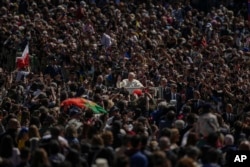 Paus Fransiskus dengan mobil kepausannya melewati kerumunan umat pada akhir misa Minggu Paskah Katolik yang dipimpinnya di Lapangan Santo Petrus di Vatikan, 17 April 2022. (Foto: AP)