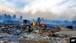 This April 20, 2022, photo provided by Bill Wells shows his home on the outskirts of Flagstaff, Ariz., destroyed by a wildfire on April 19, 2022. The wind-whipped wildfire has forced the evacuation of hundreds of homes and animals.
