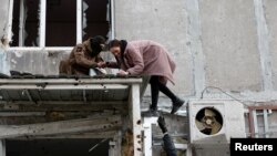 지난 17일 우크라이나 남동부 항구도시 마리우폴 시내 주거용 건물에서 주민들이 소지품을 챙겨 나오고 있다. 