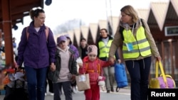 FILE - Ukrainian refugees walk on the platform after arriving on a train from Odesa at Przemysl Glowny train station, after fleeing the Russian invasion of Ukraine, in Przemysl, Poland, April 10, 2022.
