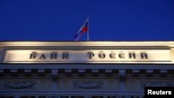 FILE - A Russian state flag flies over the Central Bank headquarters in Moscow, March 29, 2021. The sign reads "Bank of Russia". 