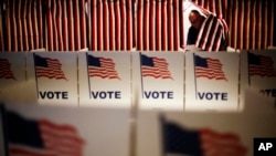 FILE - A voter in New Hampshire steps out of a voting booth after marking his ballot at a polling site for the New Hampshire primary, Feb. 9, 2016, in Nashua, New Hampshire.