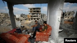 Palestinians return to the remains of their house after the ceasefire was declared, in the east of Gaza City. Aug. 27, 2014.