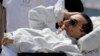 Egyptian medics and army personnel escort former Egyptian President Hosni Mubarak from a helicopter ambulance after it landed at Maadi Military Hospital following a hearing in his retrial in Cairo, April 13, 2013. 