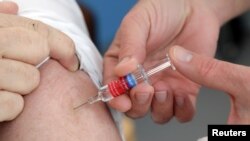 Seorang dokter sedang memberikan suntikan vaksinasi influenza musiman kepada seorang pasien di Nice, France, 24 Oktober 2017. (Foto:Dok)