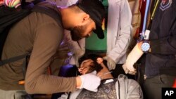 An injured protester receives first aid during clashes with security forces in Baghdad, Iraq, Friday, Jan. 31, 2020.