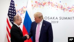 U.S. President Donald Trump, right, and Russian President Vladimir Putin greet each other during a bilateral meeting.