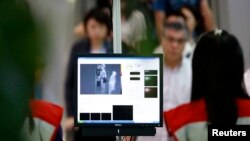 Passengers are screened as they arrive at Yangon International Airport in Yangon, Myanmar, August 20, 2014.
