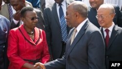 FILE - Ugandan Minister of Health Jane Aceng (L) shakes hands with Prime Minister Ruhakana Rugunda during the ceremony of the official commissioning of new radiotherapy machine at Mulago hospital in Kampala, Jan. 19, 2018.