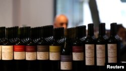 A man is seen behind bottles of wine inside a wine store in Buenos Aires, Argentina, Nov. 8, 2017.