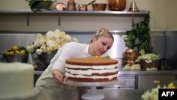 Claire Ptak, pemilik toko kue Violet Bakery di Hackney, sebelah timur London, menyelesaikan kue pengantin untuk pernikahan Pangeran Harry dan aktris Amerika, Meghan Markle di dapur Istana Buckingham, 17 Mei 2018.