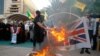 Supporters of the Iran-backed Kataib Hezbollah militia burn representations of Israeli, U.S. and British flags during a protest against the United Arab Emirates and Bahraini normalization agreement with Israel in Najaf, Iraq, Sept. 18, 2020.