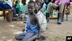 一名南苏丹小男孩坐在地上看着乐施会分发救援物资。（2018年8月17日）