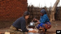 Cameron Beach, left, sieves maize flour as she helps prepare a meal, in Dedza, near Lilongwe, Malawi, July 23, 2021. 