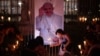People place lit candles close to a picture of Pope Francis during a vigil to pray for his health in Buenos Aires on March 7, 2025.