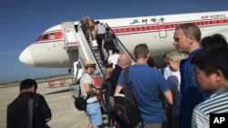 FILE - Penumpang menaiki pesawat Air Koryo menuju Beijing, di Bandara Internasional Pyongyang di Pyongyang, Korea Utara, 27 Juni 2015.