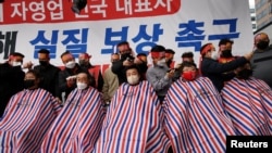 Aksi pangkas rambut hingga nyaris gundul para pemilik UKM di Seoul, Korea Selatan, memprotes perpanjangan jam malam dan pembatasan di tengah merebaknya varian omicron, 25 Januari 2022. (REUTERS/Kim Hong-Ji)