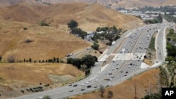 In this July 25, 2019, photo, U.S. Highway 101 passes between two separate open space preserves on conservancy lands in the Santa Monica Mountains in Agoura Hills, Calif. (AP Photo/Marcio Jose Sanchez)