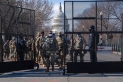 FILE - Members of the National Guard change shifts as they exit through security fencing, Jan. 16, 2021, in Washington as security is increased ahead of the inauguration of Joe Biden as president.