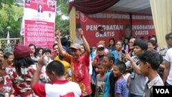Anak-anak di bawah umur tertegun menyaksikan goyangan artis dangdut dalam kampanye PKPI di Jakarta, 17 Maret 2014 (VOA/Andylala)