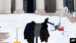 Petugas membersihkan salju di Washington.